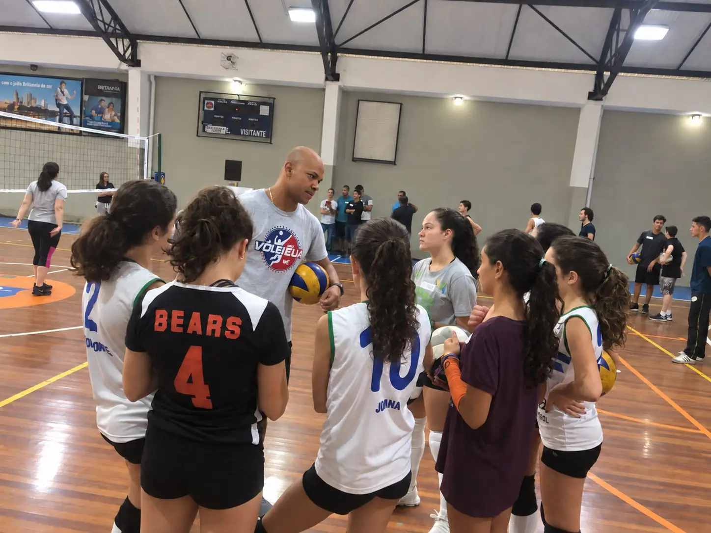 Rodrigo orientando um grupo de atletas em quadra