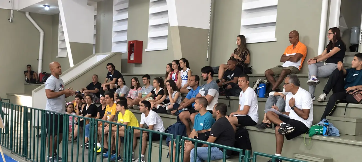 Rodrigo conduzindo um workshop para atletas e pais na arquibancada